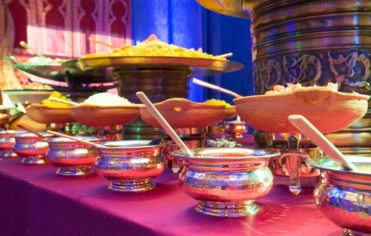 A memorable catering was designed with a lavish buffet table adorned with multiple bowls of food.