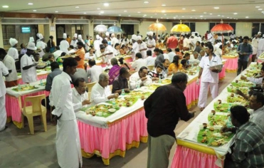 Festive scene of guests dining at a large table, showcasing wedding hospitality and guest management