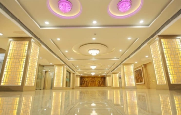In a grand ballroom, twinkling lights cover the ceiling in purple, creating a romantic atmosphere.