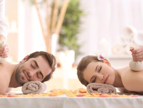 A man and woman enjoy a calming couples massage in a spa, ideal for a bride and groom's retreat.