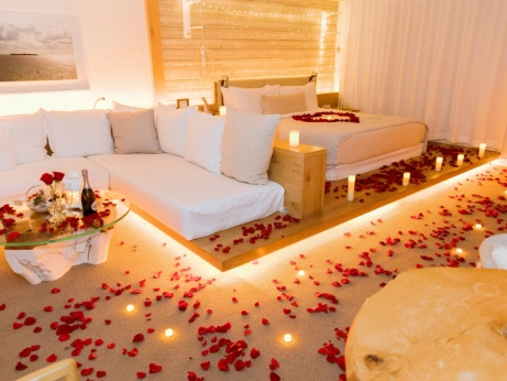 A charming bedroom with a bed, couch, and elegant candles, crafted as a romantic setting for a wedding