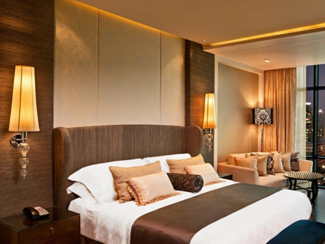 Elegant hotel room with a large bed and stunning city view, ideal for wedding guest accommodations