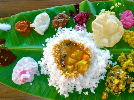 An Indian thali meal with rice, sambar, and various accompaniments served on a banana leaf.