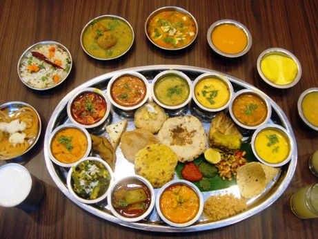 A variety of South Indian dishes, filled in a large plate, showcase colors and diverse textures.