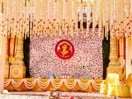 Colorful flowers and garlands decorate the stage elegantly, reflecting traditional wedding decor.