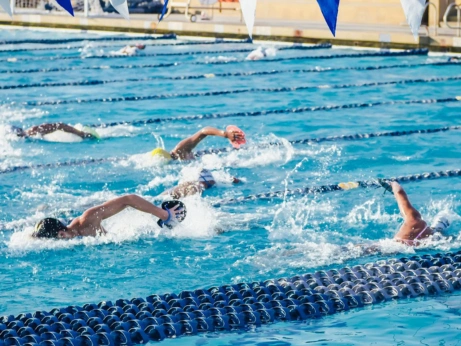 A group of swimmers practicing in a pool, preparing for pre-wedding fitness through swimming lessons