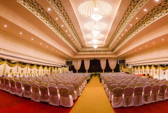A spacious banquet hall featuring arranged tables and chairs, ready for a grand event or celebration.
