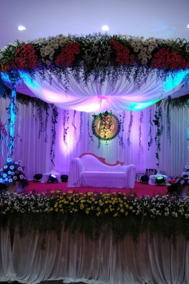 beautifully decorated stage adorned with flowers and twinkling lights, creating an atmosphere.